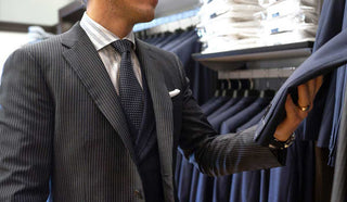 Image of man holding up a suit from the rack