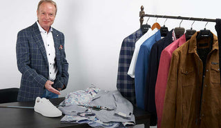 Image of Matthew pointing towards a table with clothing on it