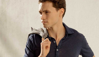 Image of man holding a blazer over his shoulder and wearing a polo shirt