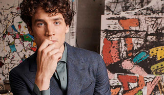 Image of man wearing a Boglioli jacket with a painting as background