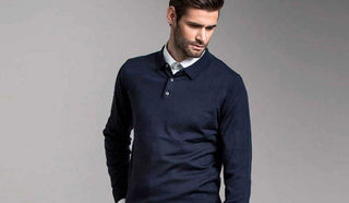 Picture of man wearing a dark blue sweater over a white shirt