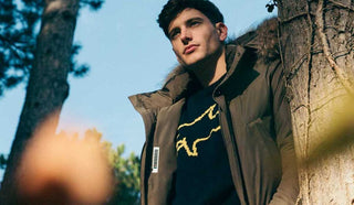 Picture of man leaning against a tree, wearing a Paul & Shark sweater and jacket