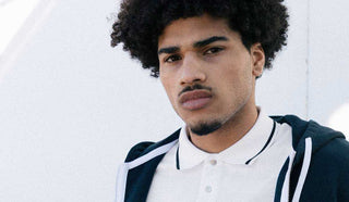 Image of man wearing a dark blue sweater and a polo shirt