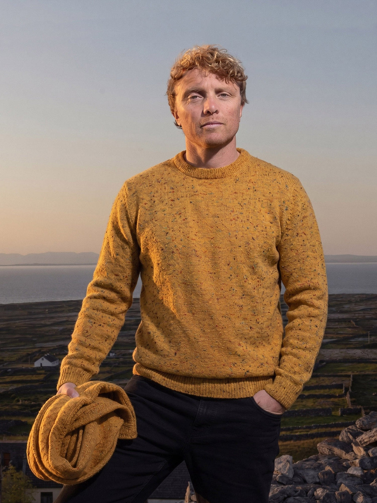 Inis Meáin Donegal crewneck in yellow fleck, at sunset above stone-walled fields