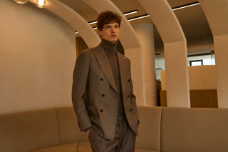A man in a brown double-breasted Luigi Bianchi Mantova suit in warm evening light